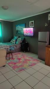 uma sala de estar com uma cama e uma televisão em St Michael and The Queens em Joanesburgo
