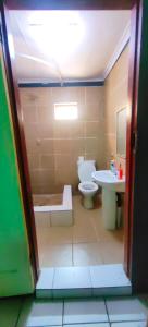 uma casa de banho com um WC e um lavatório em St Michael and The Queens em Joanesburgo