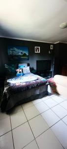 um quarto com uma cama numa parede preta em St Michael and The Queens em Joanesburgo