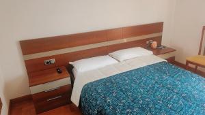 um quarto com uma cama com uma cabeceira de madeira em Habitación Renfe em Pamplona