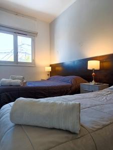 2 camas en un dormitorio con ventana en Hotel Estrella Andina en San Juan