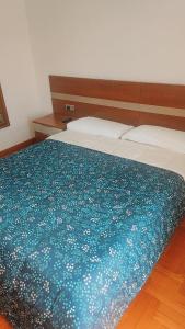 a bedroom with a bed with a blue blanket at Habitación Renfe in Pamplona
