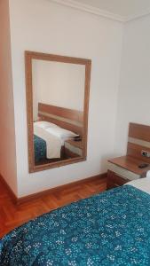 a mirror in a hotel room with a bed and a bed sidx sidx sidx at Habitación Renfe in Pamplona