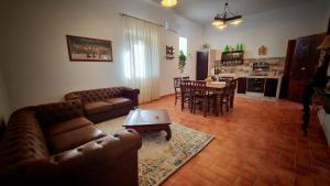a living room with a couch and a table and a kitchen at Villa Ginevra in Balestrate