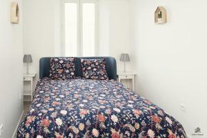 une chambre avec un lit avec un couvre-lit fleuri dans l'établissement La résidence Jeanne d'Arc 1 , Troyes - France, à Troyes