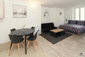 un salon avec une table et un canapé dans l'établissement La résidence Jeanne d'Arc 1 , Troyes - France, à Troyes