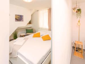 a white bedroom with a bed in a room at Lavanda in Tribunj