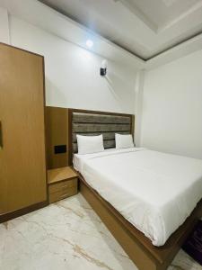 マトゥラーにあるHotel City Star Family Stayのベッドルーム(白い大型ベッド1台、木製ヘッドボード付)