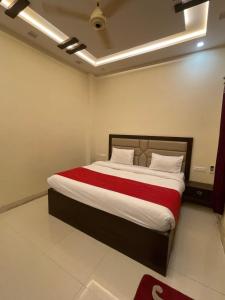 1 dormitorio con 1 cama grande con manta roja en Hotel City Star Family Stay en Mathura