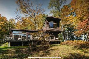 a wooden house on a hill in the woods at Casa Del Rio in Margaretville