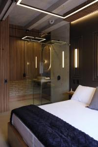 - une chambre avec un lit et une douche en verre dans l'établissement BINDI, à Salento
