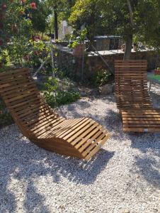 dos sillas de madera están sentadas en un patio en Casa Asfodeli - Villetta in campagna con piscina, en Cuglieri