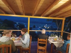 un grupo de personas sentadas en una mesa en un restaurante en Guest House Hasko, en Gjirokastra