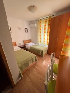 - une chambre avec 2 lits et une chaise dans l'établissement Villa Ruzica, à Trogir