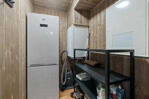 a small kitchen with a refrigerator and a shelf at Cozy Apartment close to Hovden alpine centre in Hovden
