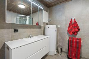 a bathroom with a white sink and a mirror at Cozy Apartment close to Hovden alpine centre in Hovden +13 photos