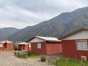 a group of buildings with mountains in the background at Cabañas Entre Cerros in San José de Maipo