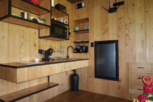 a kitchen with wooden walls and a sink and a tv at Alto's Gardens in Fortuna
