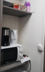 尼姆的住宿－Chambre spacieuse dressing WC et SDB communes，架子上的微波炉,上面有咖啡壶