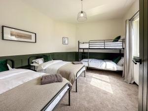 een slaapkamer met 3 stapelbedden en een raam bij The Bunker - Garesfield Golf Course in Newcastle upon Tyne