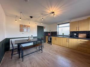 a large kitchen with a table and a dining room at The Bunker - Garesfield Golf Course in Newcastle upon Tyne