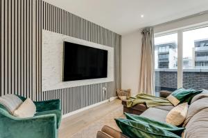 ein Wohnzimmer mit 2 Sofas und einem Flachbild-TV in der Unterkunft Khayat Homes - The Emerald - Two Bed Luxury Apt in North Woolwich