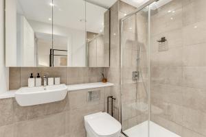 ein Bad mit einem WC, einem Waschbecken und einer Dusche in der Unterkunft Khayat Homes - The Emerald - Two Bed Luxury Apt in North Woolwich