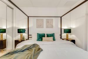 ein Schlafzimmer mit einem großen weißen Bett mit grünen Kissen in der Unterkunft Khayat Homes - The Emerald - Two Bed Luxury Apt in North Woolwich