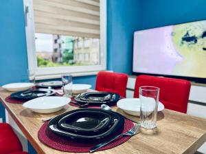 une table en bois avec des assiettes et des verres dans l'établissement NJ Deluxe rooms, à Varna