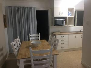 a kitchen with a wooden table and chairs in a kitchen at Creekside at Hat Head - 7 Creek Street in Hat Head