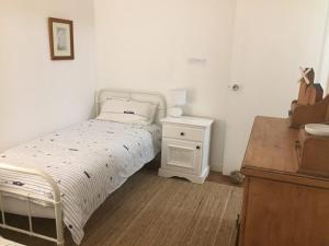 a small bedroom with a bed and a night stand at Creekside at Hat Head - 7 Creek Street in Hat Head