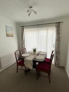 a dining room with a table and chairs and a window at The Marlene - Lovely 3-Bed Home - Free WIFI & Parking - Short or Long Stays in Burton upon Trent