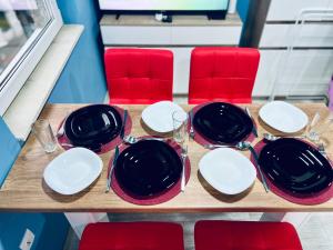 une table avec des assiettes noires et blanches et des chaises rouges dans l'établissement NJ Deluxe rooms, à Varna 70 autres photos
