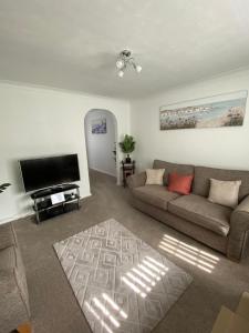 a living room with a couch and a flat screen tv at The Marlene - Lovely 3-Bed Home - Free WIFI & Parking - Short or Long Stays in Burton upon Trent