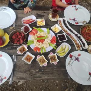 un tavolo con piatti di cibo sopra di ida bay doğa evleri a Edremit