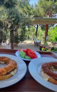 two white plates of food on a wooden table at ida bay doğa evleri in Edremit