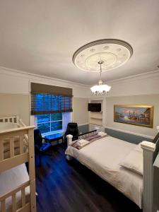 a bedroom with a bed and a chandelier at Ivybank Villa in Rothesay