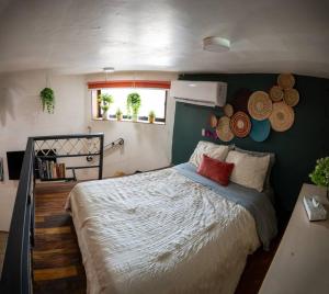 Un dormitorio con una cama grande y una pared verde en “Encantador Loft” - en el corazón de San Pedro, en Guadalajara