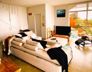 uma sala de estar com um sofá e uma televisão em Stunning Views over Tasman Bay em Nelson