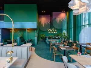 un ristorante con pareti e tavoli e sedie verdi di ibis Styles Rotterdam Ahoy a Rotterdam