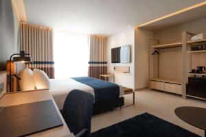 Best Western Premier Malta في خليج سانت بول: غرفة في الفندق مع سرير ومكتب