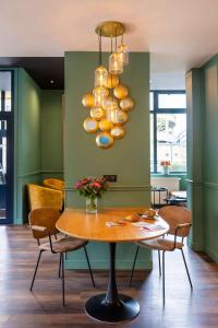 uma sala de jantar com uma mesa e um lustre em Best Western Metz Centre Gare em Metz