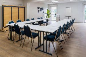 uma sala de conferências com uma mesa longa e cadeiras em Best Western Bourgoin Jallieu em Bourgoin-Jallieu