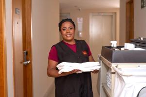 a woman is holding a pile of towels at Nobile Hotel Juiz de Fora in Juiz de Fora