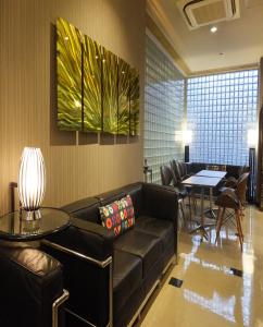 - une salle d'attente avec un canapé et une table dans l'établissement APA Hotel Takamatsu Kawaramachi, à Takamatsu