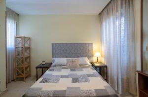 1 dormitorio con 1 cama grande y 2 mesitas de noche en Habitación doble con baño compartido en Benalmadena en Benalmádena