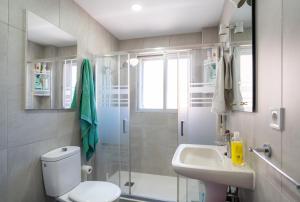 y baño con ducha, aseo y lavamanos. en Habitación doble con baño compartido en Benalmadena, en Benalmádena
