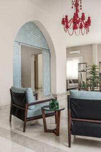 uma sala de estar com um espelho, uma cadeira e uma mesa em Livingville The Two-Fifty em Cairo