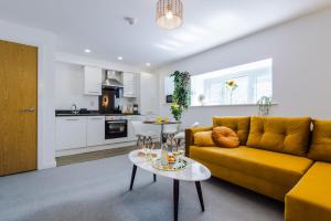 a living room with a yellow couch and a table at Westlea in Leeds