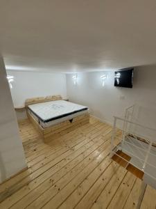 a room with a bed and a wooden floor at B&B Gin&Sol in Naples